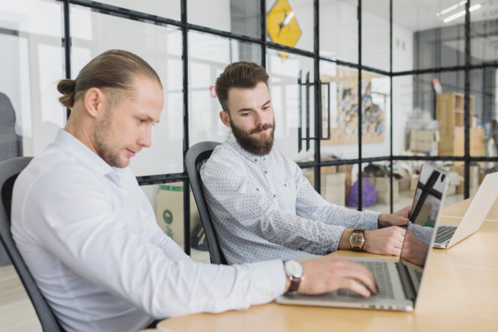 Business planning workspace with financial documents and laptop showing spreadsheets